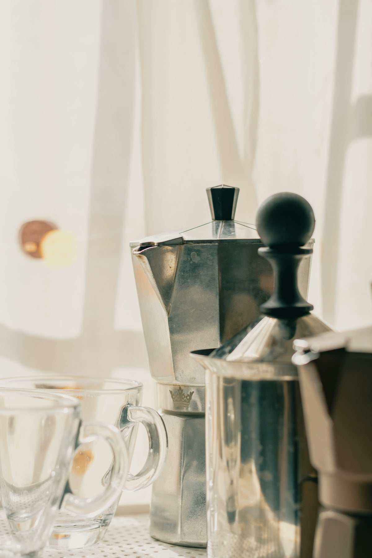 Stovetop espresso maker, polished stainless steel with a black knob and lid; Solving Common Problems brewing guide feature
