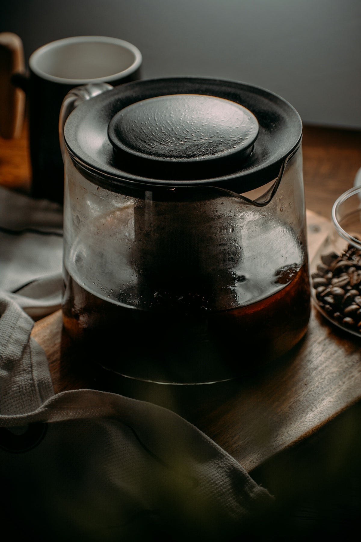 a coffee pot with a lid sitting on top of a wooden table