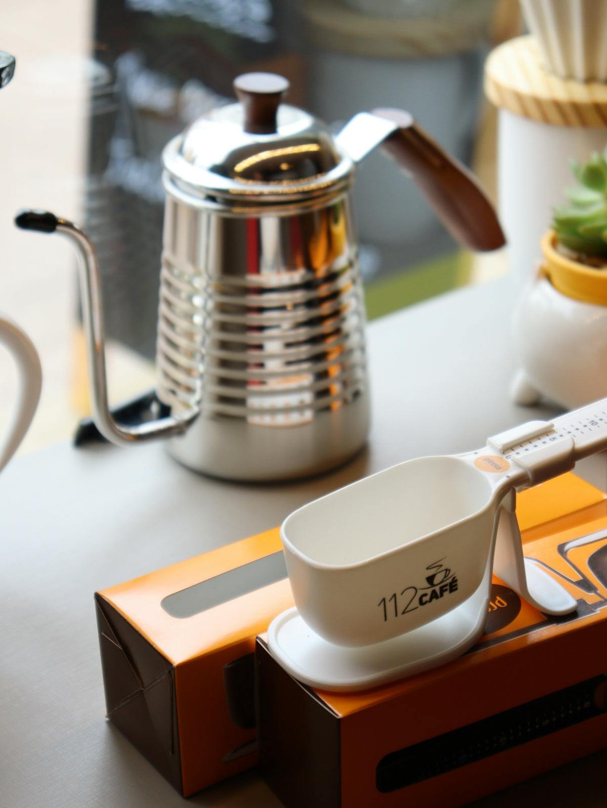 Tea brewing accessory set with polished stainless steel kettle, white measuring cup and scoops; Enhance Your Daily Tea Routine