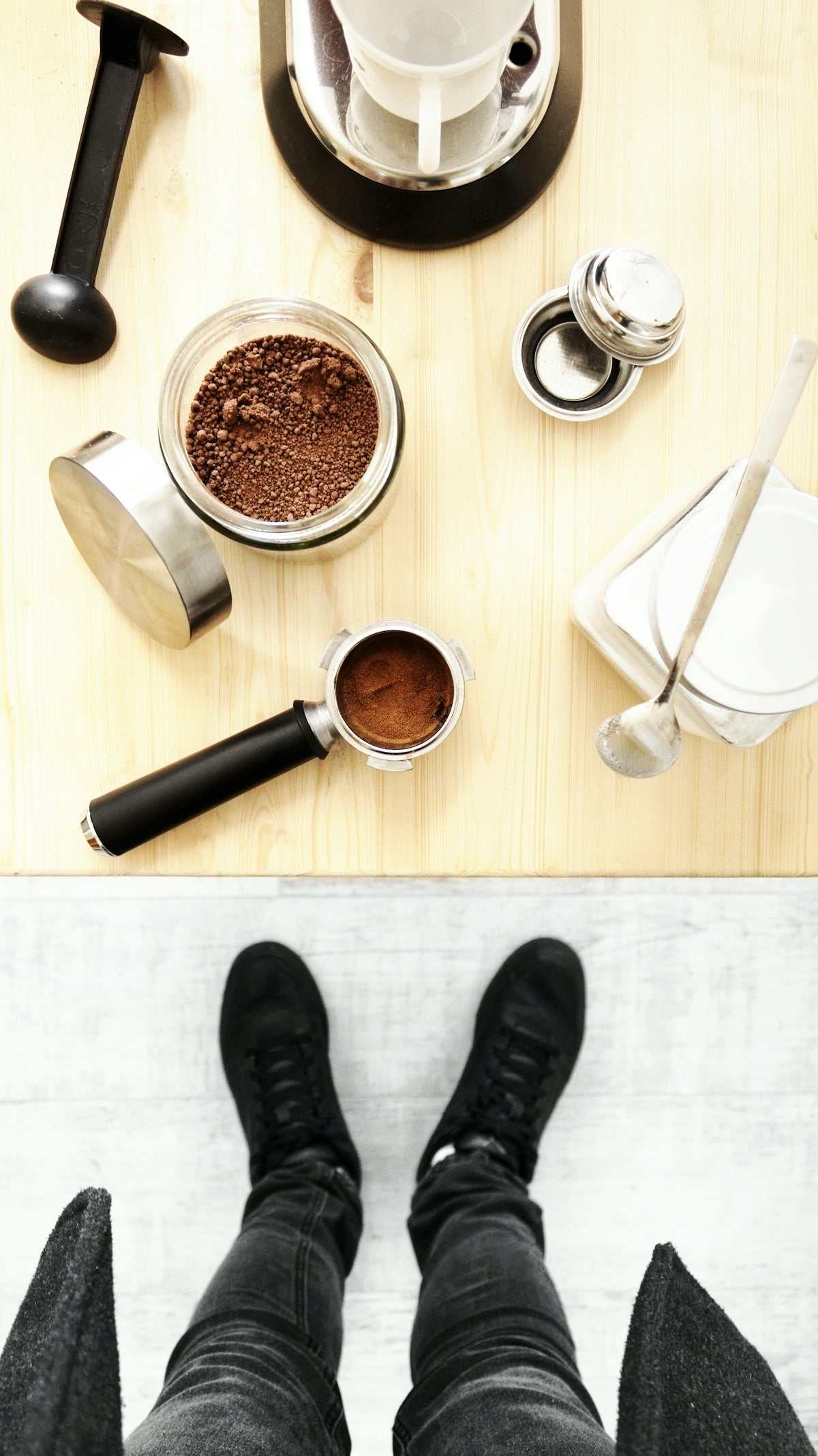 Coffee brewing accessories in black and stainless steel, with grounds, portafilter and tamper; Checkalist Essentials kitchen setup.
