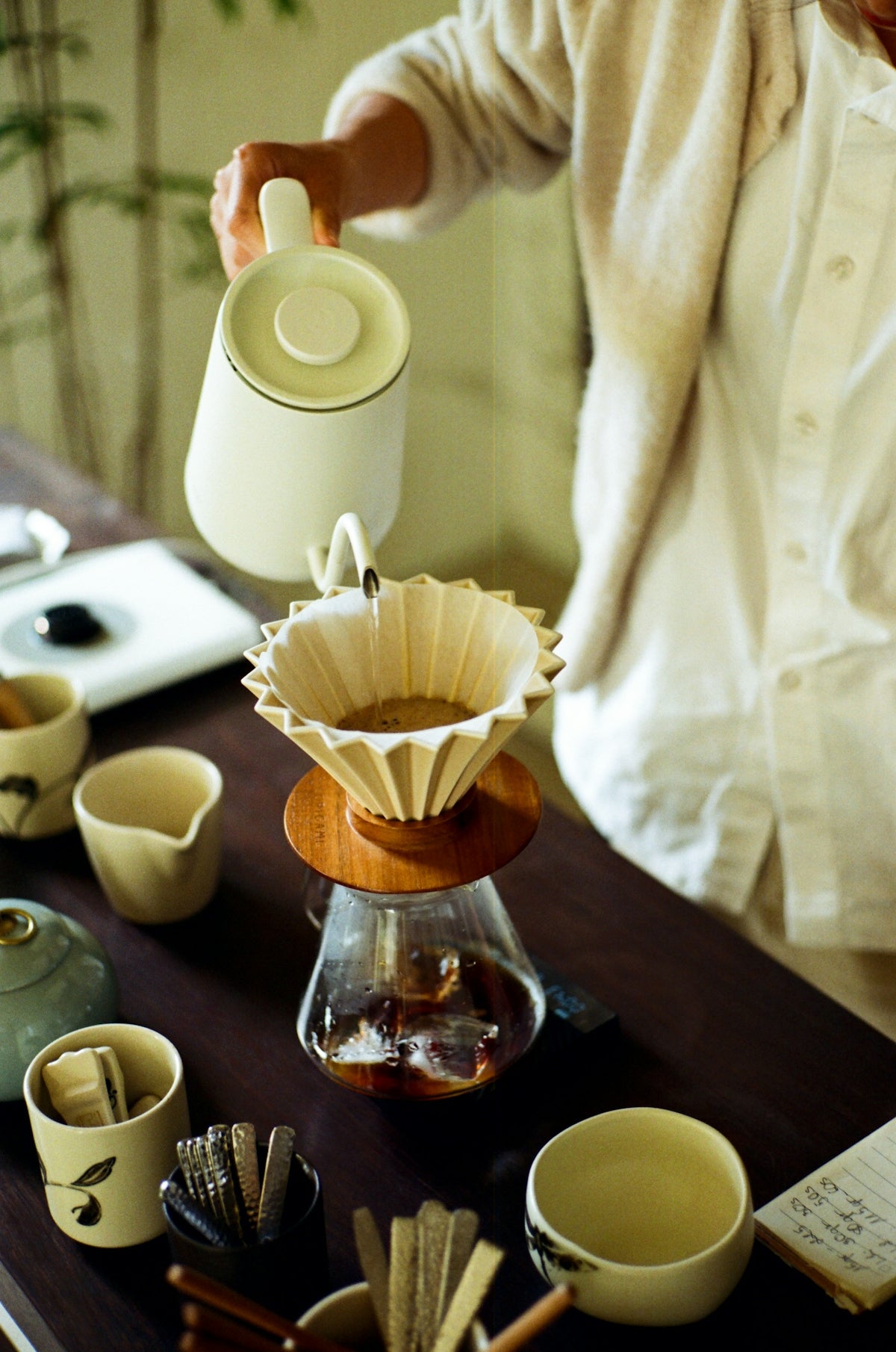 Person pouring hot water into coffee dripper